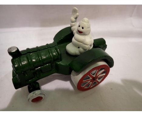 Cast iron Michelin man on tractor, L: 13 cm. P&amp;P Group 1 (£14+VAT for the first lot and £1+VAT for subsequent lots) 