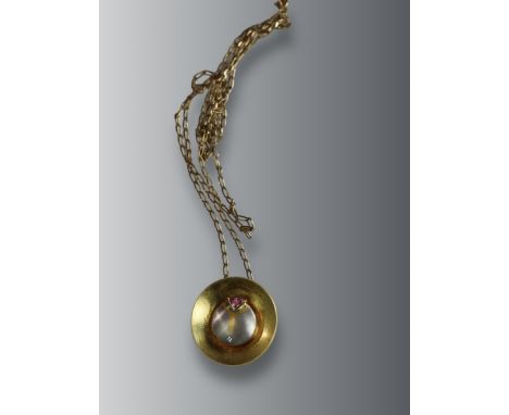 An Unusual Gold, Platinum, Diamond and Ruby Disc Pendant, on a long chain, chain set in 9 ct gold, pendant set in 18 ct gold 
