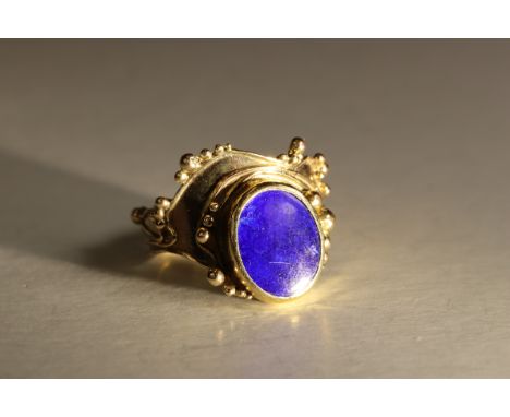 A Lapis Lazuli and 9 ct Yellow Gold Dress Ring, circa 1970. The oval-shaped lapis lazuli stone within a rub-over setting, in 