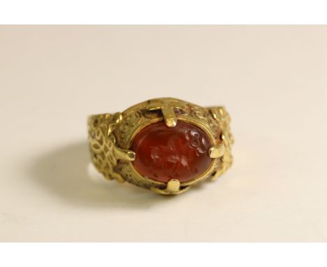 An ancient-style Carnelian Intaglio and Yellow Gold Dress Ring The oval intaglio engraved with a prancing bull, claw-set with