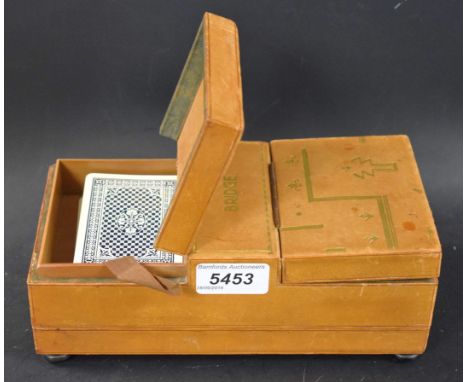 An early 20th century pig skin bridge box, twin hinged covers enclosing provision for playing cards, above a further hinged c