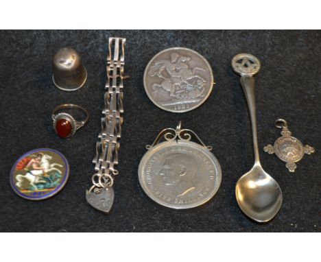 A silver teaspoon; a silver ring, set with a single polished oval carnelian cabochon; a George IIII silver crown coin, 1821, 