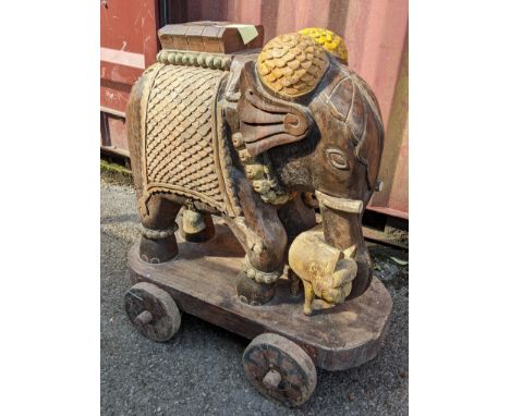 An Indian teak carved model of an elephant mounted on a cart, 89cm high x 83cm wideLocation:If there is no condition report s