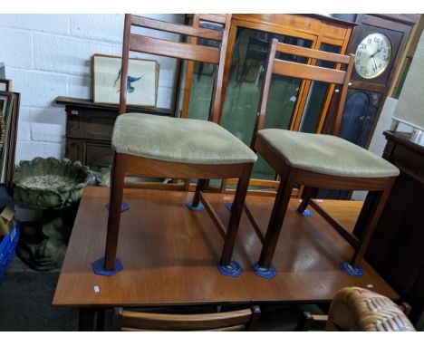 A mid-century teak extending dining table on shaped square legs 74cm x 127cm x 81cm, with six matching dining chairs with lig