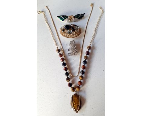 A small quantity of costume jewellery to include a tigers eye necklace on gold tone chain, a modern gold tone, enamelled and 