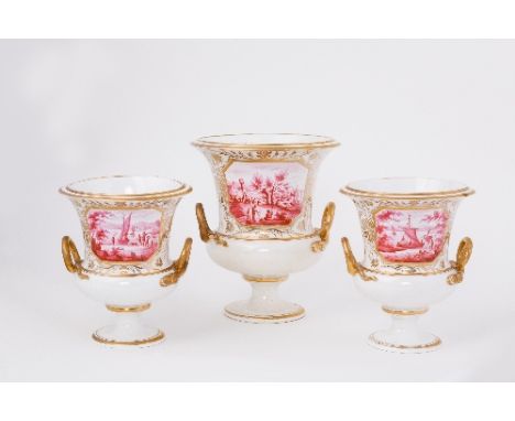 A Derby garniture of three campana vases, painted to the front in pink with figures in riverside landscapes, gilt cartouches,