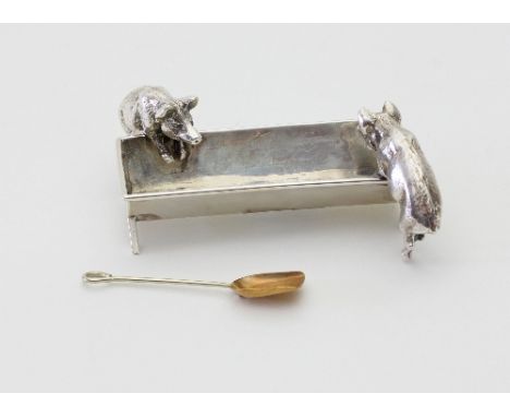 A novelty salt cellar, London 1900, modelled as two piglets feeding at a trough, 9cm wide and a salt shovel for the same Cond