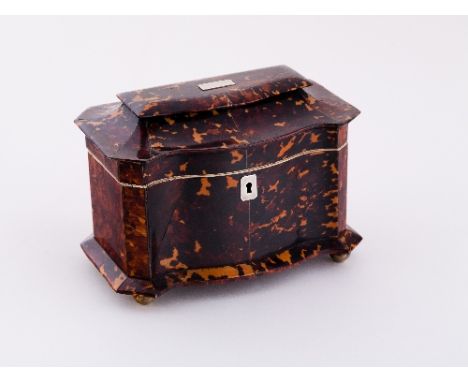 A Regency tortoiseshell sarcophagus shaped tea caddy, with serpentine front and canted sides, the interior fitted twin lidded