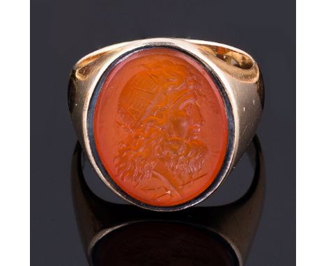 A hardstone intaglio, circa 1800, depicting a head above a trident, in a 19th Century ring mount, the oval intaglio 18mm x 14