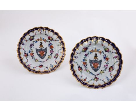 A pair of Worcester armorial plates, painted with a coat-of-arms and crest, within a floral wreath and fruit garlands, circa 