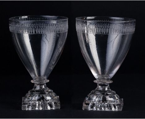 A pair of Georgian rummers, the tapered bowls cut flutes on square lemon squeezer bases, 13.5 high Condition Report: One with