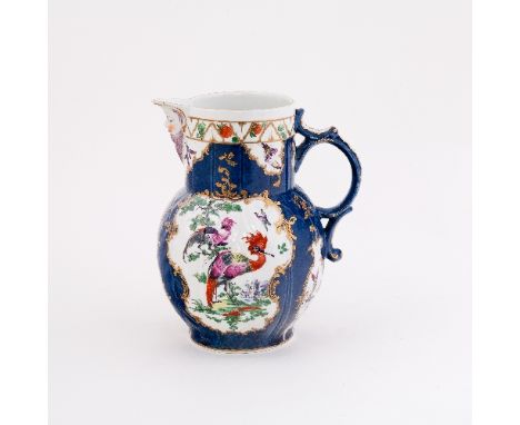 A Worcester cabbage-leaf jug with mask spout, painted with opposing reserves of exotic birds in landscape within gilt cartouc