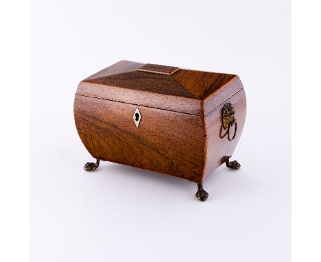 A Regency rosewood sarcophagus shaped tea caddy, with boxwood stringing and lion mask ring handles to the sides, with twin li