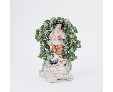 A Derby figure of a shepherd playing a pipe before bocage, circa 1775, 23cm high
