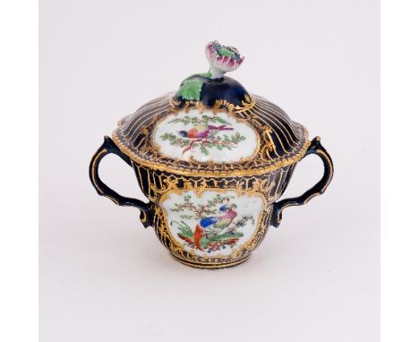 A Worcester blue ground two-handled chocolate cup, of ogee form, painted with reserves of exotic birds within gilt scroll car