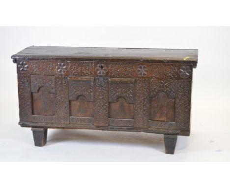 An 18th Century carved oak domed coffer, the hinged top enclosing an interior, the sizes with carved rosettes and blind fretw