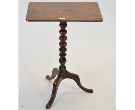 An early 19th Century mahogany occasional table, the rectangular top on a central bobbin turned support and raised on a tripa