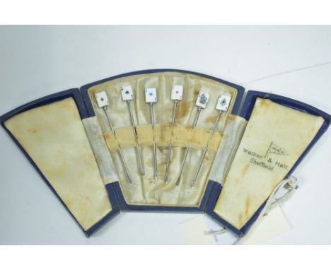 A set of six cocktail sticks, with enamel playing card finials and stamped 'Silver' to ends, in fitted case.