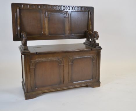 A 20 th Century carved oak monks bench, with carved lion arms, 104 x 406 x 44cms