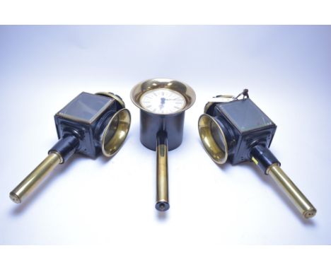 A pair of vintage black metal and brass carriage lamps; together with a novelty carriage lamp clock by Kienzle.