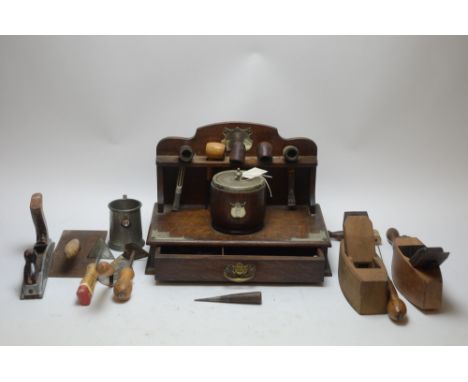An early 20th Century oak pipe rack, containing tobacco pipes and tools; together with antique woodworking tools, to include 