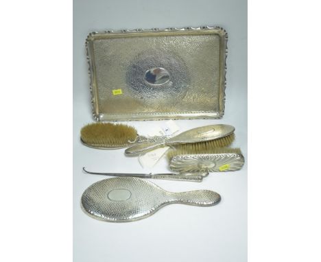 A silver dressing table set, by A&amp;J Zimmerman, Birmingham 1903, with hammered decoration, including: tray, hand mirror; b