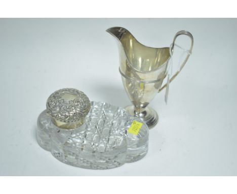 A cut glass inkwell with silver cover (hallmark worn) Birmingham 1886; together with a silver helmet form cream jug, with mid