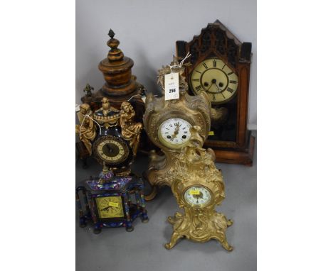 Two cast metal mantle clocks; two wooden wall clocks; a composite black and gold painted mantle clock; and another. 