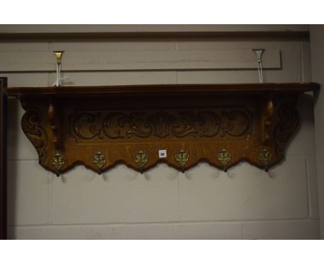 A Reproduction carved and stained oak Continental style wall shelf, with a shaped self on a carved bracket fitted six ornate 