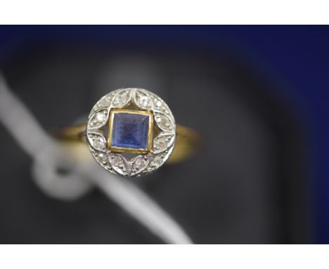 A sapphire and diamond ring, the central square facet-cut sapphire surrounded by eight-cut diamonds within an openwork mount 