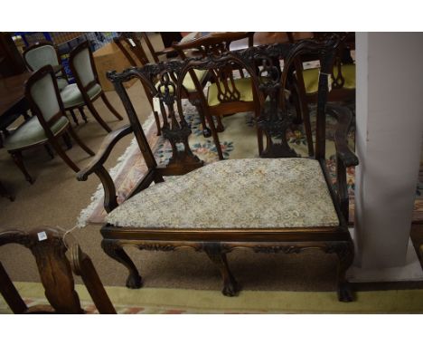 Reproduction Chippendale style chair settee with decorative carved and pierced cresting rail and splats and shaped arms raise