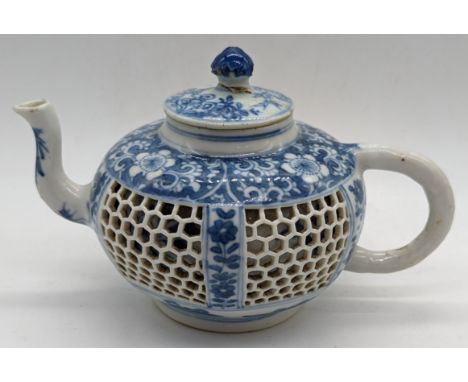 A Chinese Kangxi period blue and white teapot, honeycomb panels between sprays or peony, pierced mark to base