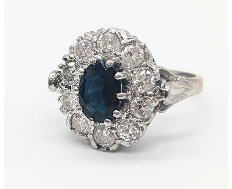 A Sapphire and Diamond cluster ring, 18ct white gold mount, oval cut Sapphire 1.01cts, surrounded by 10 round brilliant cut d