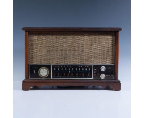 Housed in mid-century modern wood cabinet, radio has tuning dial, tone dial, switch for AM to FM and On/Off volume control. M