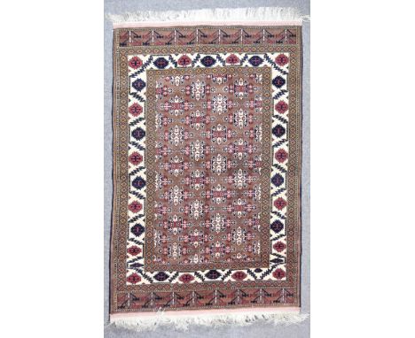 A Late 20th Century Persian Rug of Kazak Design, woven in colours of ivory, navy blue and fawn, the field filled with three r