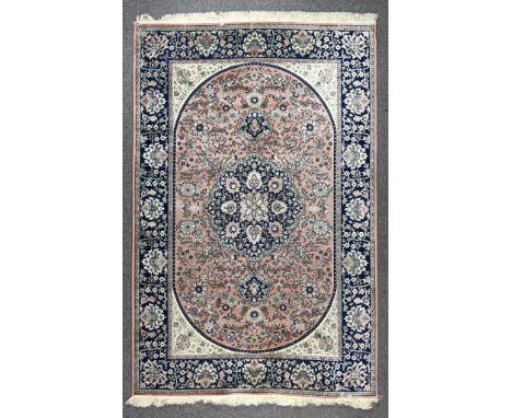 A Rug of Kashan Design, woven in pastel colours, with bold central stylised floral pole medallion on a rose ground, the field