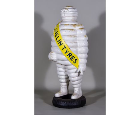 A French Cast Iron Michelin Man Advertising Figure Standing on a Tyre, with yellow sash, 23ins high