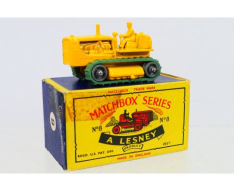 Matchbox - A boxed Matchbox Regular Wheels 8c Caterpillar Tractor. The model in yellow, metal rollers with green pliable trac
