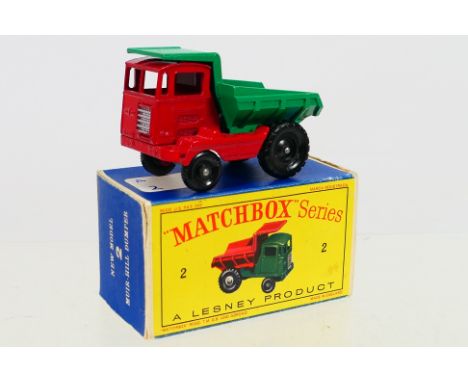 Matchbox - A boxed Matchbox Regular Wheels 2c Muir Hill Dumper. The model with Red Body, green dumper, 'Laing' decal, black p
