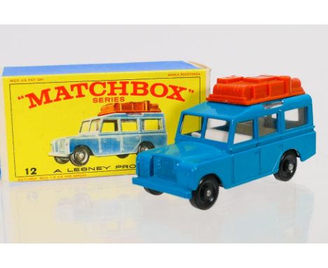 Matchbox - A boxed Matchbox Regular Wheels 12c Land Rover Safari. The model with blue body, clear glazing, burnt sienna lugga