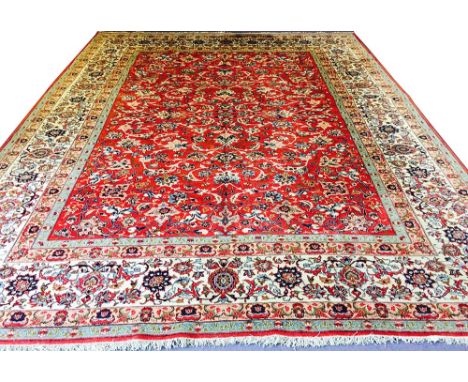 FINE ISPHAHAN CARPET, 406cm x 320cm, all over scrolling palmettes and vines on a ruby field within complimentary bands and bo