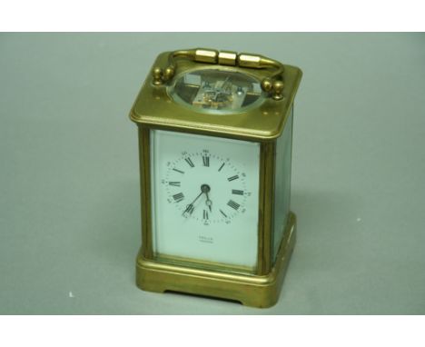 A CARRIAGE CLOCK the movement coil striking, platform escapement with enamel dial in brass and glazed case height 7" (17.5 cm