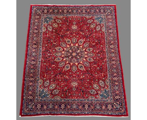 A PERSIAN STYLE CARPET with jewelled central medallion, the field with open leafy scrolls, blue border 13' (392 cms) x 9' 10"