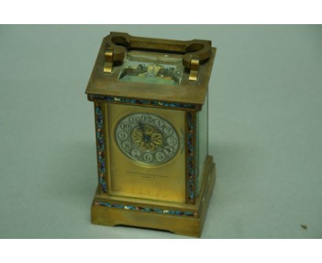 A CARRIAGE TIMEPIECE silvered chapter ring, platform escapement in brass and glazed case with champleve enamel borders height
