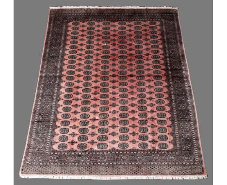 A PAKISTANI BOKHARA TYPE CARPET with six rows of guls 10' 10" (329 cms) x 8' 1" (246 cms)