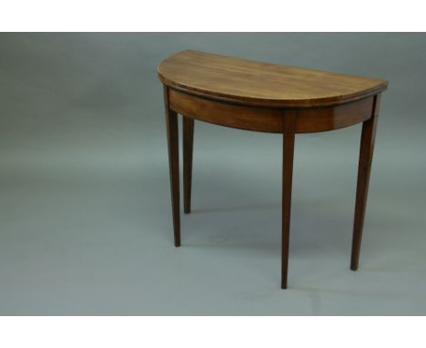 GEORGE III MAHOGANY CARD TABLE Demi lune top with boxwood stringing, now with a gilt tooled brown leather surface 36" (91.5 c