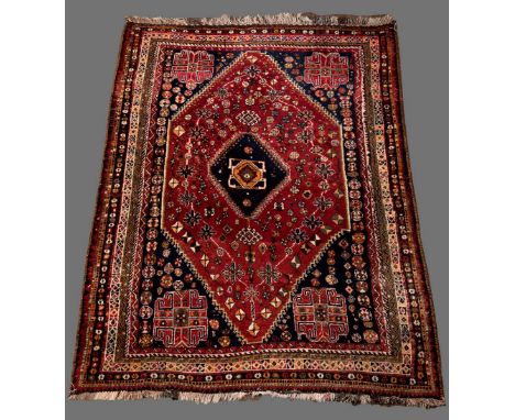 A SOUTH PERSIAN CARPET mainly in blue and red with hexagonal field 7' 8" (234 cms) x 5' 4" (164 cms)