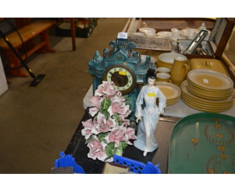 A glazed mantle clock with guilt highlight decoration; together with a floral encrusted ornament and a Royal Doulton figurine