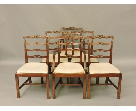 A set of sixteen George III style mahogany dining chairs, with pierced wavy ladder backs and drop in seats, twelve singles an