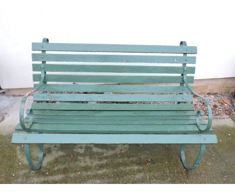 A wrought iron garden bench, with wooden slats